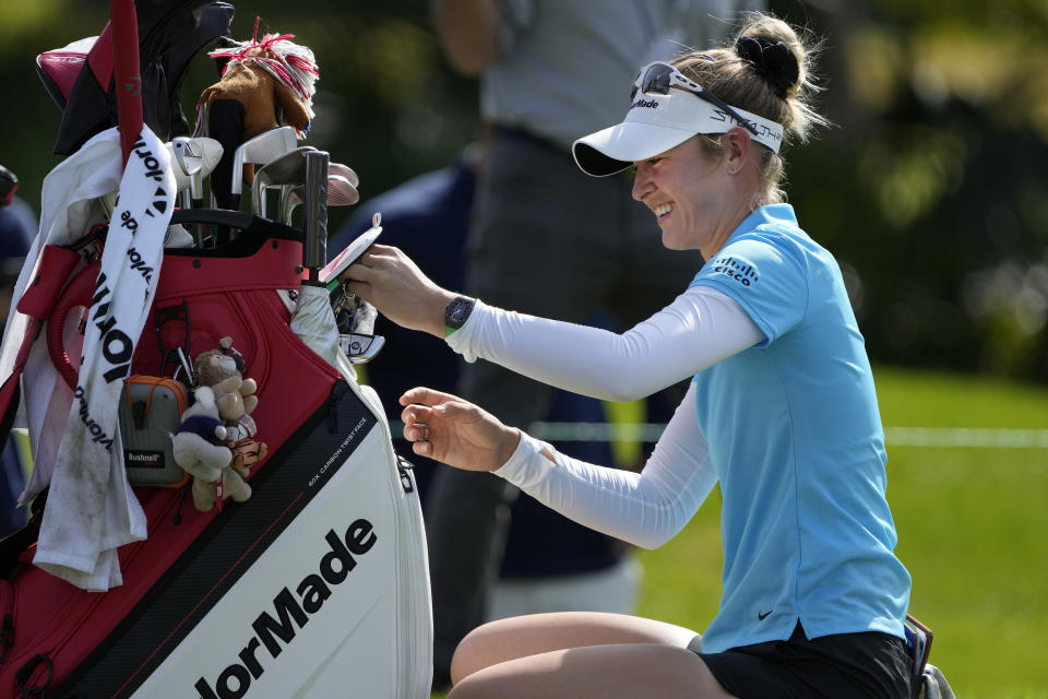 Nelly Korda reaches into her golf bag while waiting to tee off on the 10th hole during the first round of the Hilton Grand Vacations Tournament of Champions LPGA golf tournament Thursday, Jan. 19, 2023, in Orlando, Fla. (AP Photo/John Raoux)
