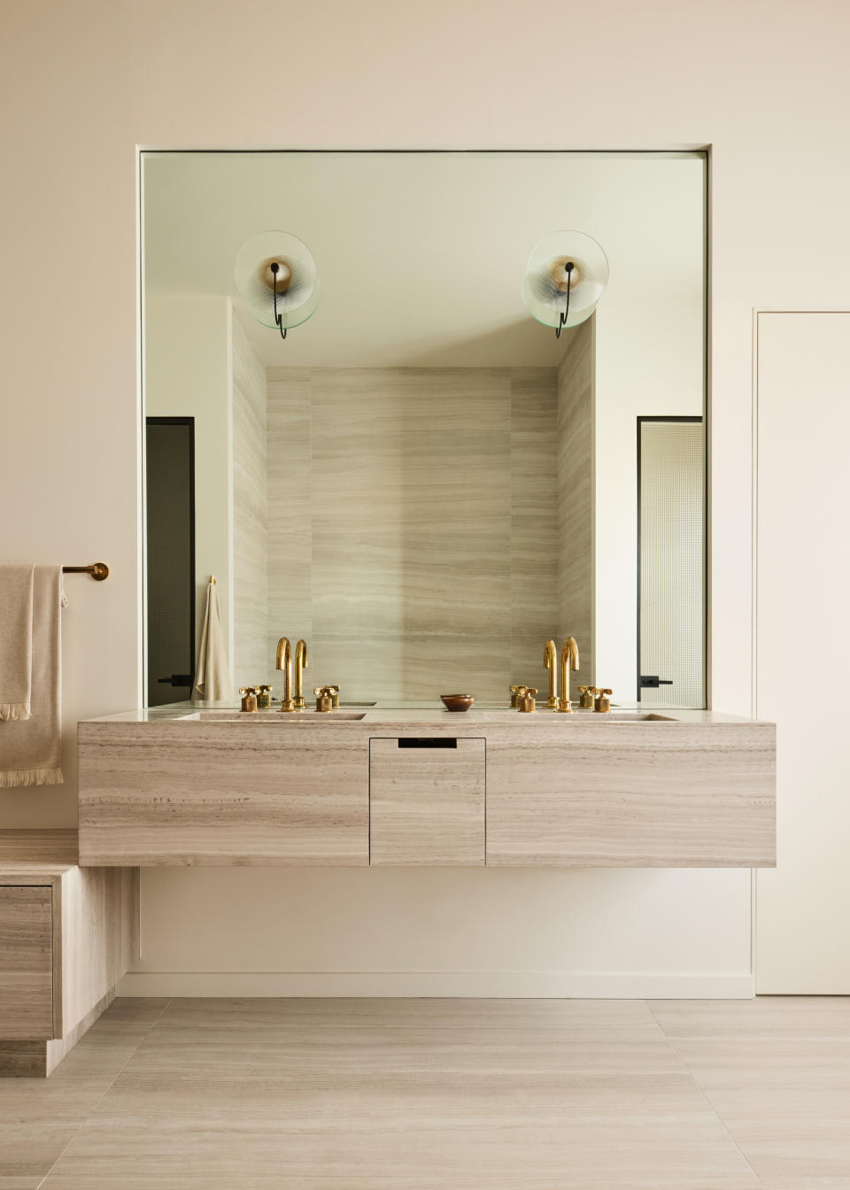 A bathroom with travertine trough sink