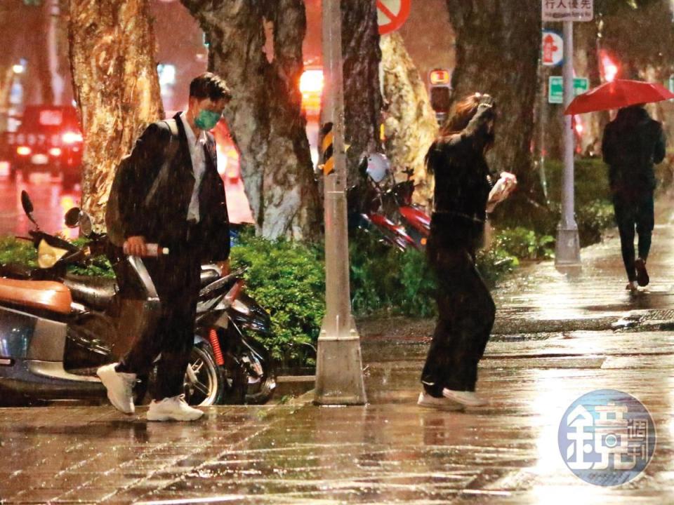 當天飄著細雨，周興哲（左）沒脫下外套為女友遮雨，趙岱新（右）以手護頭疾步走往騎樓。