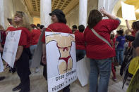 <p>Sonya Ashby, a library media specialist at Lubeck Elementary in Wood County, shows off her sign at the West Virginia State Capitol on the second day of the teacher walkout in Charleston, W.Va., on Friday, Feb. 23, 2018. (Photo: Craig Hudson/Charleston Gazette-Mail via AP) </p>