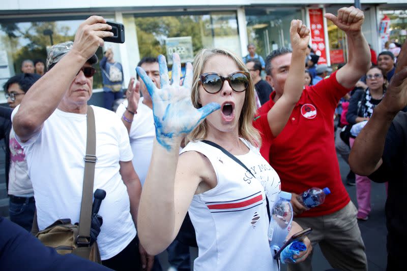 Opposition demonstrators yell at supporters of Mexico's President Andres Manuel Lopez Obrador (not pictured) after a march to protest against violence on the first anniversary of President Andres Manuel Lopez Obrador taking office, in Mexico City