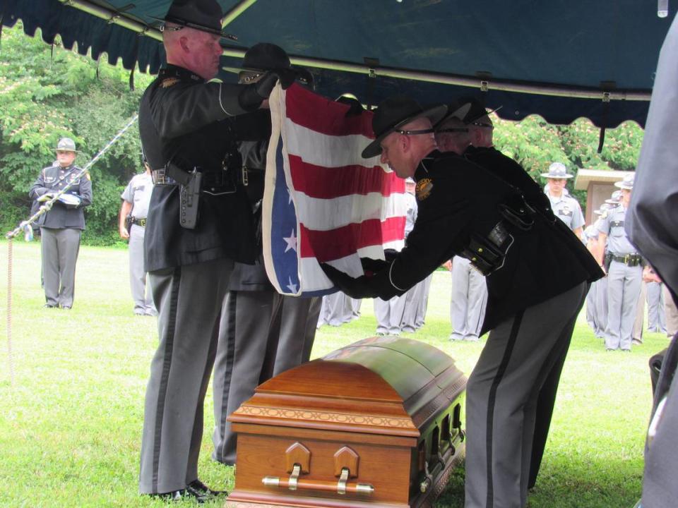 Members of a Kentucky State Police honor guard folded the U.S. flag from atop the casket of slain Floyd County, Ky, Deputy William Petry during his funeral on July 5, 2022.