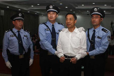 Ousted Chinese politician Bo Xilai (2nd R) is handcuffed after the announcement of his verdict inside the court in Jinan, Shandong province September 22, 2013, in this photo released by Jinan Intermediate People's Court. REUTERS/Jinan Intermediate People's Court/Handout via Reuters