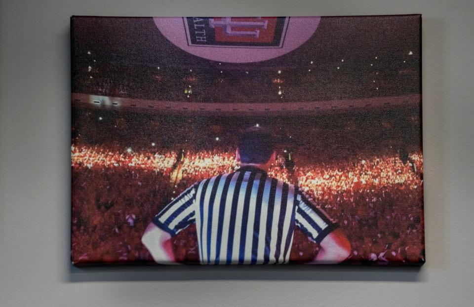 Bo Boroski  has this photo of himself on the basketball court for the IU vs North Carolina, Big 10 ACC Challenge, from 2016, on the wall of his offices Thursday, March 2, 2023 at RefQuest. He retired from NCAA basketball officiating in 2022. Now he is the CEO of RefQuest which he founded in 2018.