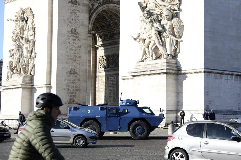 A police armored vehicle park at the Arc de Triomphe, Saturday, Feb.12, 2022 in Paris. Protesters angry over pandemic restrictions are driving toward Paris to blockade the French capital despite a police ban. The protesters organized online, galvanized in part by truckers who have blockaded Canada's capital. Paris region authorities deployed more than 7,000 police officers to tollbooths and other key sites to try to prevent a blockade. (AP Photo/Adrienne Surprenant)