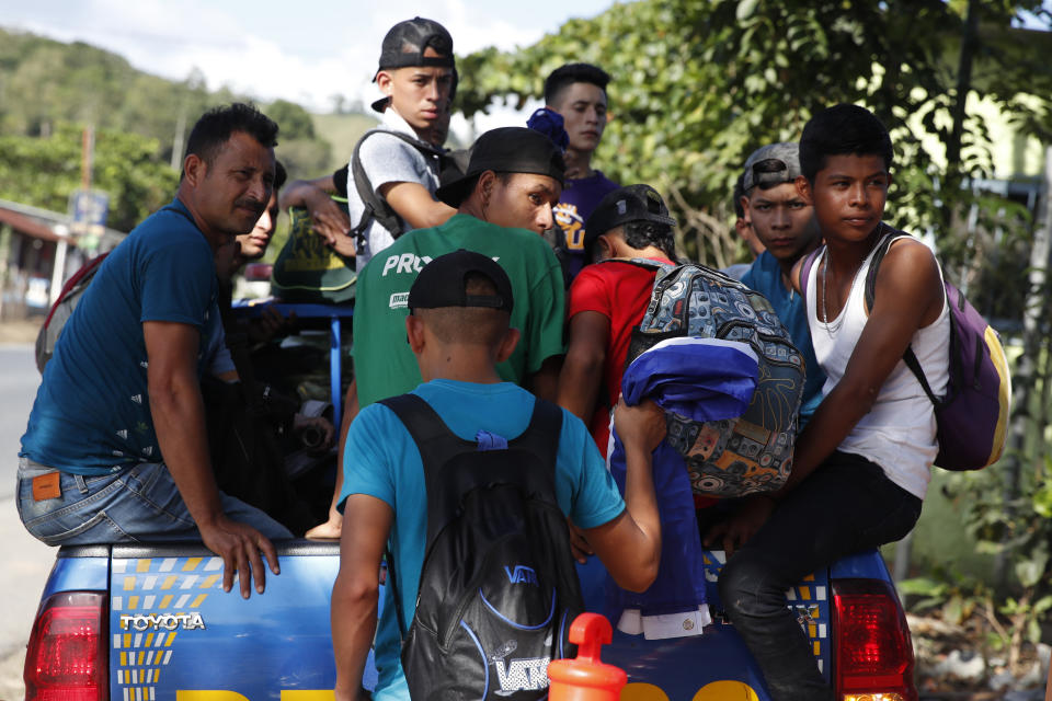 Migrantes hondureños que intentan llegar a Estados Unidos suben a la parte trasera de una camioneta policial antes de ser devueltos a la frontera con Honduras en Morales, Guatemala, el miércoles 15 de enero de 2020. (AP Foto/Moisés Castillo)