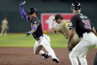 Arizona Diamondbacks' Ketel Marte is tagged out by San Diego Padres' Jake Cronenworth, right, advancing to second during the first inning of a baseball game, Saturday, May 4, 2024, in Phoenix. (AP Photo/Matt York)