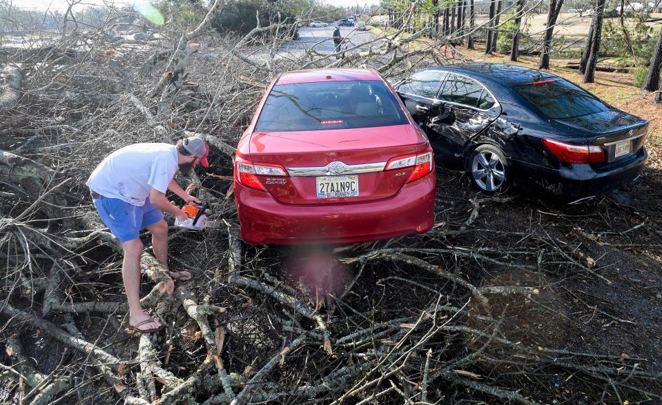 Volunteers work to clear a road and get a man trapped in his car out as storm damage is seen in Selma, Ala., after a storm ripped through the city on Thursday afternoon, January 12, 2023.