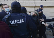 Members of a far-right organization and police remove man from a church where they were protesting church support for tightening Poland's already restrictive abortion law in Warsaw, Poland, Sunday, Oct. 25, 2020. Poland constitutional court issued a ruling on Thursday that further restricts abortion rights in Poland, triggering four straight days of protests across Poland.(AP Photo/Czarek Sokolowski)