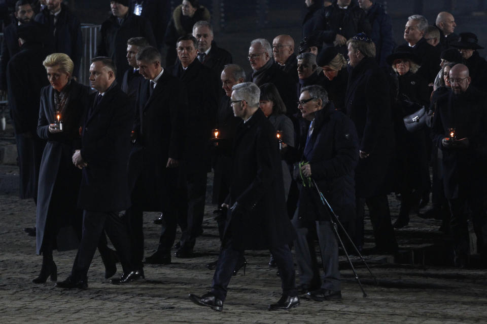 Poland's President Andrzej Duda and his wife Agata Kornhauser-Duda, left, and holocaust survivor Marian Turski, center right with cane, attend commemorations at the Auschwitz Nazi death camp in Oswiecim, Poland, Monday, Jan. 27, 2020. Survivors of the Auschwitz-Birkenau death camp gathered for commemorations marking the 75th anniversary of the Soviet army's liberation of the camp, using the testimony of survivors to warn about the signs of rising anti-Semitism and hatred in the world today. (AP Photo/Czarek Sokolowski)