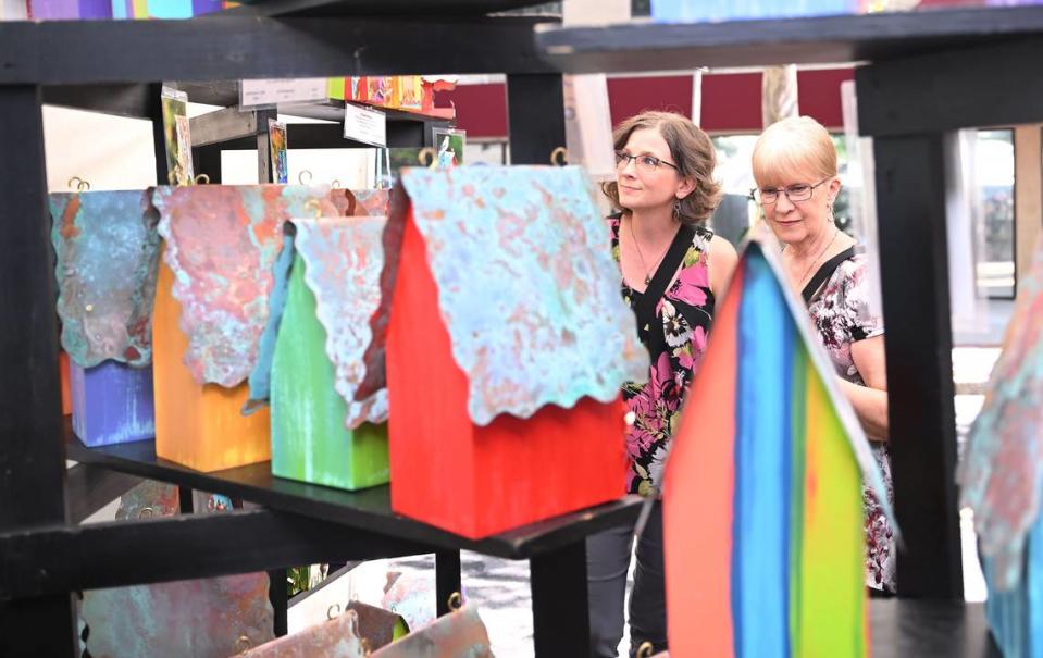 Laurie Verost, left, and Cathie Verost of Philipsburg look at birdhouses at Fly Home Birdhouses at the 57th Central Pennsylvania Festival of the Arts in July 2023.