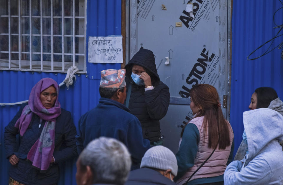 People wait outside a hospital for news of relatives after a passenger plane crashed in Pokhara, Nepal, Sunday, Jan. 15, 2023. A plane making a 27-minute flight to a Nepal tourist town crashed into a gorge Sunday while attempting to land at a newly opened airport, killing at least 68 of the 72 people aboard. At least one witness reported hearing cries for help from within the fiery wreck, the country’s deadliest airplane accident in three decades. (AP Photo/Yunish Gurung)