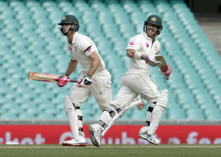 Australian batsman David Warner (R) looks back down the pitch as he scores runs alongside team mate Mitchell Marsh during their third cricket test against the West Indies in Sydney, January 7, 2016. REUTERS/Jason Reed