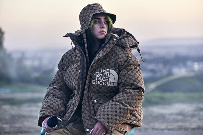 Billie wearing a printed North Face/Gucci puffer jacket with matching bucket hat