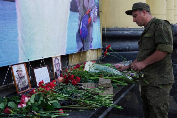 A Russian serviceman pays tribute to Yevgeny Prigozhin (L) and Dmitry Utkin, a shadowy figure who managed Wagner's operations (AFP via Getty Images)