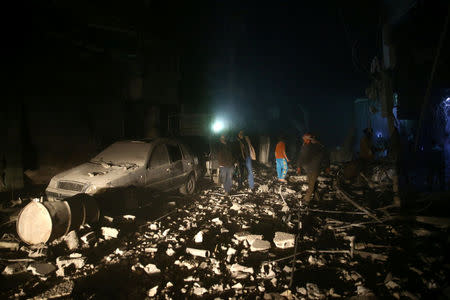 People are seen inspecting the damage after an air raid in the besieged town of Douma in eastern Ghouta in Damascus, Syria February 8, 2018. REUTERS/Bassam Khabieh