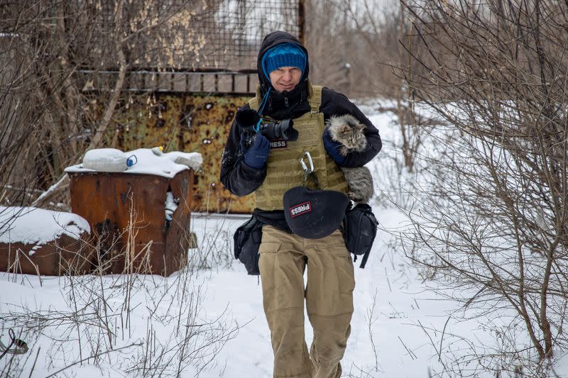 FOTO DE ARCHIVO: El fotógrafo ucraniano Maksim Levin lleva un gato cerca de la línea de separación de los separatistas apoyados por Rusia en la región de Donetsk, Ucrania.