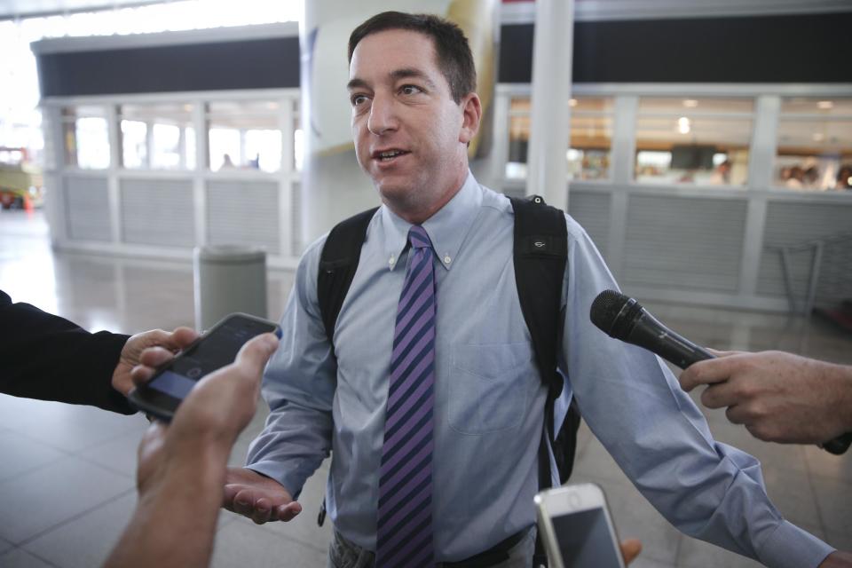 Glenn Greenwald speaks to the media after arriving at John F. Kennedy International Airport, on Friday, April 11, 2014 in New York. Greenwald and Laura Poitras of the Guardian share a George Polk Award for national security reporting with The Guardian's Ewen MacAskill and Barton Gellman, who has led The Washington Post's reporting on the NSA documents. Greenwald returned to the United States for the first time since the story broke to receive the journalism award. (AP Photo/John Minchillo)