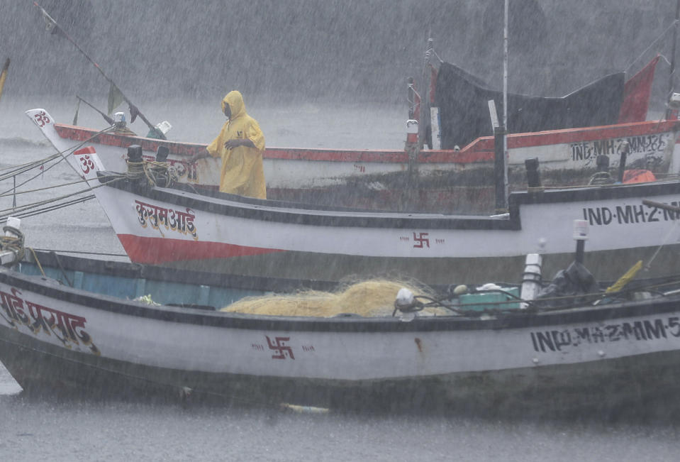 A fisherman waits for help as he tries to move a fishing boat to a safer ground on the Arabian Sea coast in Mumbai, India, Monday, May 17, 2021. Cyclone Tauktae, roaring in the Arabian Sea was moving toward India's western coast on Monday as authorities tried to evacuate hundreds of thousands of people and suspended COVID-19 vaccinations in one state. (AP Photo/Rafiq Maqbool)