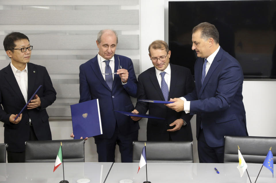 Cyprus' Energy Minister Georgios Lakkotrypis, right, General Manager of Total in Cyprus Yves Grosjean, second right, Manager director of ENI Cyprus Allesandro Barberis, second left, and Director of Kongas Cyprus Insu Woo hold the files after signing a deal at the Energy ministry in Nicosia, Cyprus, Wednesday, Sept. 18, 2019. Cyprus' energy minister says a consortium made up of energy companies Total of France and Eni of Italy has been granted a license to explore for natural gas deposits in another area off Cyprus' southern coast. (AP Photo/Petros Karadjias)