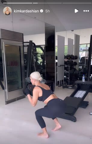 <p>Kim Kardashian/Instagram</p> Kim Kardashian squats with weights during her workout