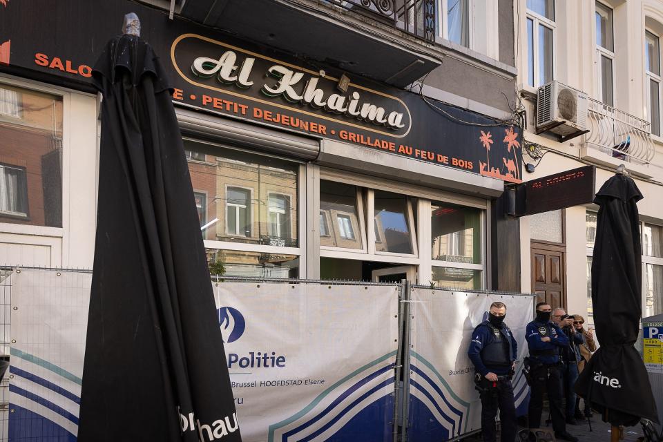 Belgian police officers stand outside cafe Al Khaima in the Schaerbeek area of Brussels (BELGA/AFP via Getty Images)