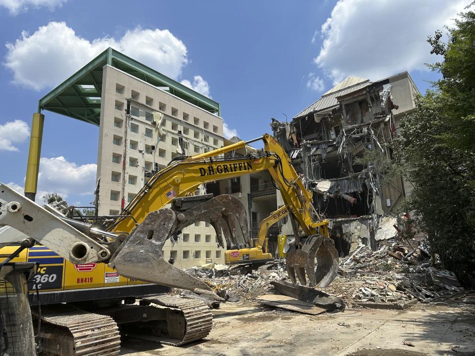 Workers knock down a former Coca-Cola Co. museum in downtown Atlanta on Friday, May 14, 2024. The World of Coca-Cola museum moved to a new site in downtown Atlanta in 2006 and Georgia state government is demolishing the vacant structure to turn it into a parking lot. (AP Photo/Jeff Amy)