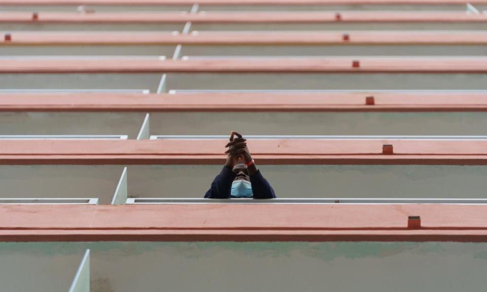 A young man who made the crossing waits on the balcony of a hotel room in Tenerife, where he was house temporarily, for the arrival of the bus to take him to Las Canteras camp for migrants, 16 March 2021.