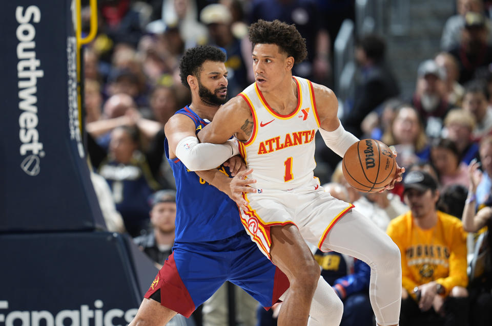 Atlanta Hawks forward Jalen Johnson (1) drives to the basket as Denver Nuggets guard Jamal Murray defends in the second half of an NBA basketball game Saturday, April 6, 2024, in Denver. (AP Photo/David Zalubowski)