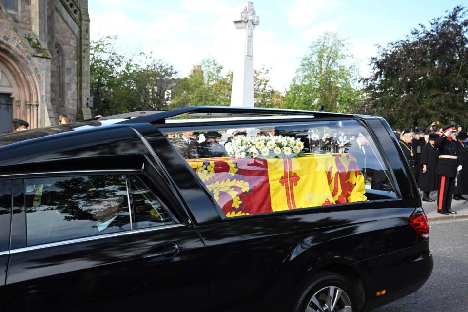 11 September 2022: Members of the Public pay their respects as the hearse carrying the coffin of Queen Elizabeth II, draped in the Royal Standard of Scotland, is driven through Ballater (AFP/Getty)