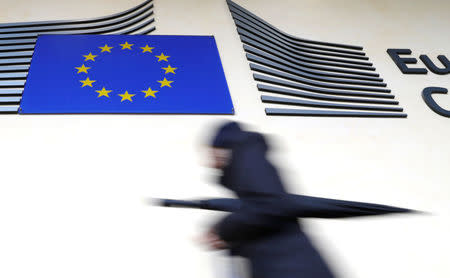 A woman walks past the European flag outside the EU Commission headquarters in Brussels, Belgium March 1, 2017. REUTERS/Yves Herman