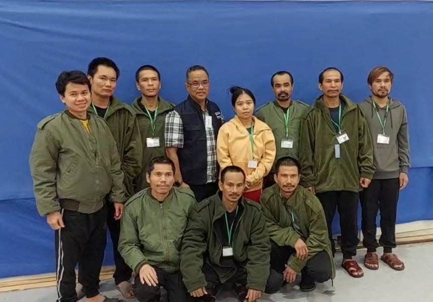 Thai workers taken hostage by Hamas and later released as part of a deal between Israel and Palestinian Islamist group Hamas, pose with a member of Thai mission after a medical checkup, in Tel Aviv, Israel, in this handout image released on November 25, 2023.