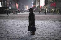 A man stands in falling snow on West 42nd street in Times Square in New York, January 26, 2015. REUTERS/Mike Segar