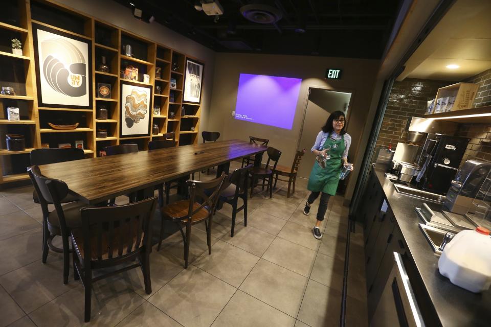 In this Wednesday, Jan. 15, 2020, photo, Belith Ariza, a barista trainer at Starbucks, does some prep work at a barista training station in the community meeting space at a local Starbucks Community Store, in Phoenix. (AP Photo/Ross D. Franklin)