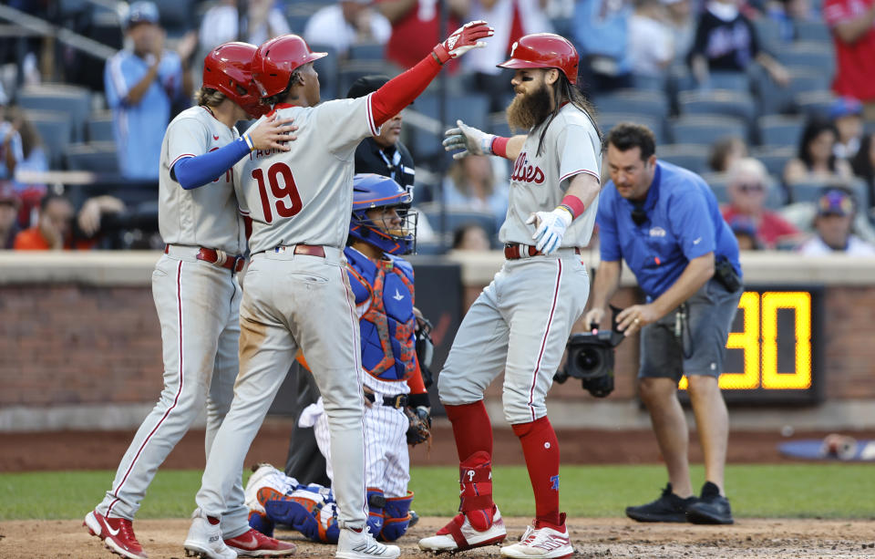 Philadelphia Phillies' Bryson Stott and Cristian Pache (19) greet Brandon Marsh, front right, at home plate after scoring on Marsh's home run against the New York Mets during the ninth inning of a baseball game, Sunday, Oct. 1, 2023, in New York. (AP Photo/Noah K. Murray)