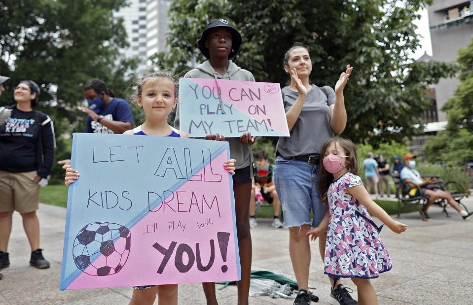 Rachel Jones and her daughters Julia, 8, Felicia, 13, and Sophia, 4, listen to speakers during a protest against transgender sports bill at the Ohio statehouse last June.