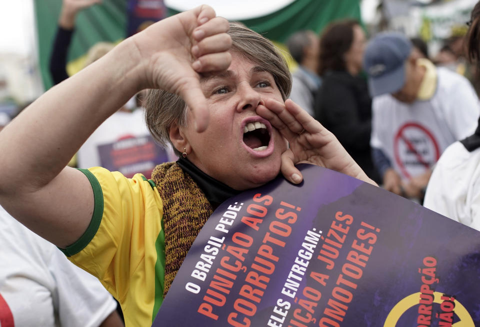 A woman shouts slogans against corruption during a rally in support of the government's "Car Wash" investigation into corruption on Copacabana beach, Rio de Janeiro, Brazil, Sunday, Aug. 25, 2019. Supporters of the president and the justice minister called for the nationwide demonstration. (AP Photo/Silvia Izquierdo)