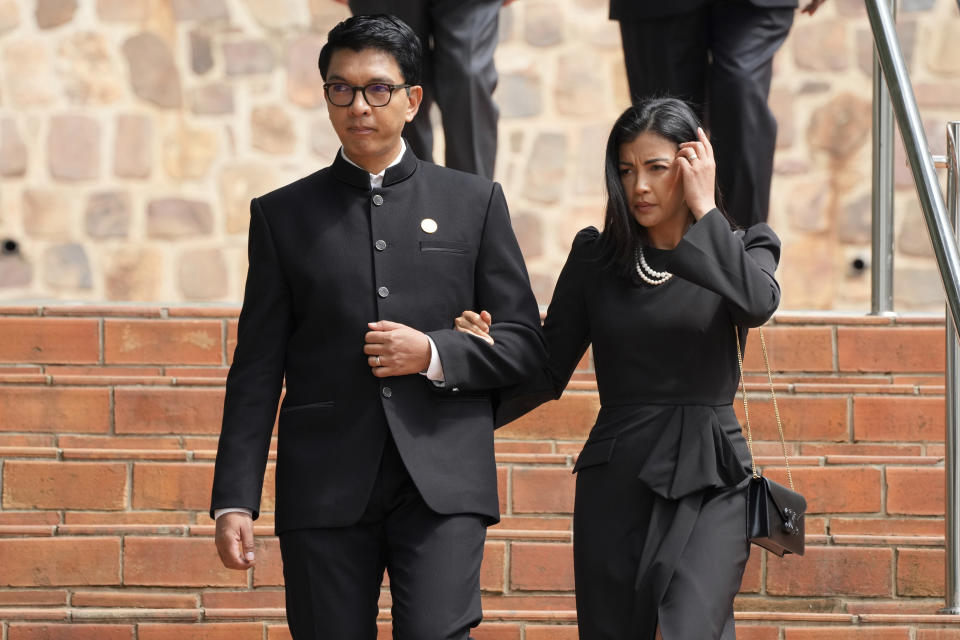 President of Madagascar Andry Rajoelina, left, and his wife Mialy Rajoelina arrive for a ceremony to mark the 30th anniversary of the Rwandan genocide, held at the Kigali Genocide Memorial, in Kigali, Rwanda, Sunday, April 7, 2024. Rwandans are commemorating 30 years since the genocide in which an estimated 800,000 people were killed by government-backed extremists, shattering this small east African country that continues to grapple with the horrific legacy of the massacres. (AP Photo/Brian Inganga)