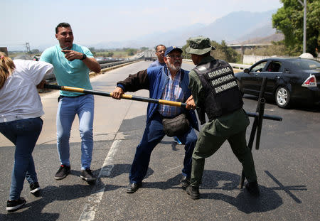 Lawmaker members of the Venezuelan National Assembly and supporters of the Venezuelan opposition leader Juan Guaido, who many nations have recognised as the country's rightful interim ruler, clash with security forces as they block the road on the outskirts of Mariara, Venezuela February 21, 2019. REUTERS/Andres Martinez Casares