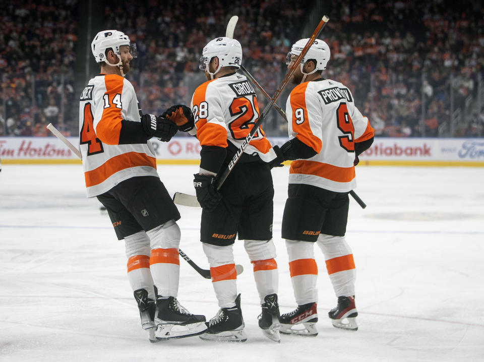 Philadelphia Flyers' Sean Couturier (14), Claude Giroux (28) and Ivan Provorov (9) celebrate a goal against the Edmonton Oilers during the first period of an NHL hockey game, Wednesday, Oct. 27, 2021 in Edmonton, Alberta. (Jason Franson/The Canadian Press via AP)