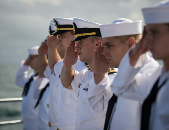 Members of the US Navy salute in honor of Apollo 11 astronaut Neil Armstrong during his burial at sea service aboard the USS Philippine Sea, Friday, Sept. 14, 2012, in the Atlantic Ocean. Armstrong, the first man to walk on the moon during the