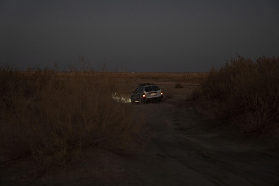 A car with Afghan migrants drives near the village Islam Qala, on Wednesday, Nov. 24, 2021, on Afghanistan-Iran border in their effort to cross into Iran. Afghans are streaming across the border into Iran, driven by desperation after the near collapse of their country's economy following the Taliban's takeover in mid-August. In the past three months, more than 300,000 people have crossed illegally into Iran, according to the Norwegian Refugee Council, and more are coming at the rate of 4,000 to 5,000 a day. (AP Photo/Petros Giannakouris)