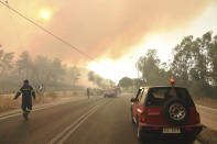 Firefighters operate during a wildfire near Lampiri village, west of Patras, Greece, Saturday, Jul. 31, 2021. The fire, which started high up on a mountain slope, has moved dangerously close to seaside towns and the Fire Service has send a boat to help in a possible evacuation of people. (AP Photo/Andreas Alexopoulos)