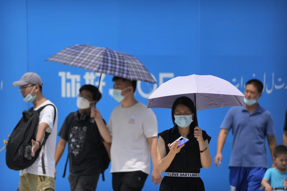 Visitors wear face masks to protect against COVID-19 as they walk at a tourist shopping street in Beijing, Tuesday, Aug. 3, 2021. Chinese authorities announced Tuesday mass coronavirus testing in Wuhan as an unusually wide series of COVID-19 outbreaks reached the city where the disease was first detected in late 2019. The current outbreaks, while still in the hundreds of cases in total, have spread much more widely than previous ones, reaching multiple provinces and cities including the capital, Beijing. (AP Photo/Mark Schiefelbein)