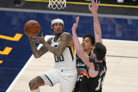 San Antonio Spurs' Tre Jones, center, and Drew Eubanks (14) defend against Utah Jazz guard Jordan Clarkson (00) as he passes the ball during the first half of an NBA basketball game Wednesday, May 5, 2021, in Salt Lake City. (AP Photo/Rick Bowmer)