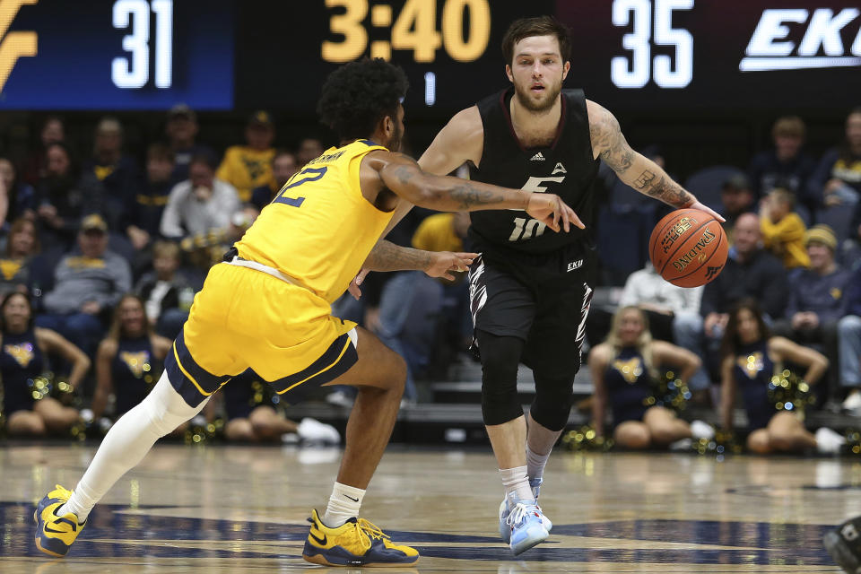 Eastern Kentucky guard Braxton Beverly (10) is defended by West Virginia guard Taz Sherman (12) during the first half of an NCAA college basketball game in Morgantown, W.Va., Friday, Nov. 26, 2021. (AP Photo/Kathleen Batten)