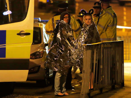 FILE PHOTO: Two women wrapped in thermal blankets stand near Manchester Arena, northern England, Britain, May 23, 2017. REUTERS/Andrew Yates/File Photo