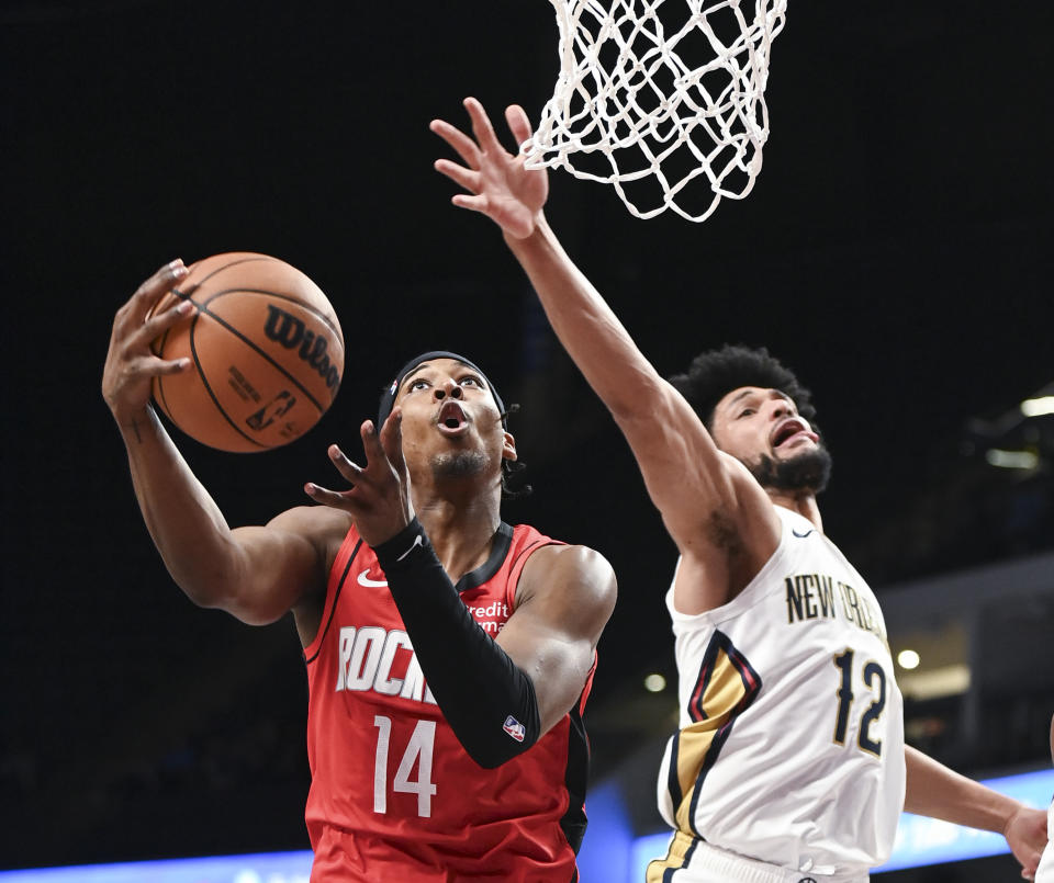 Houston Rockets guard Nate Hinton (14) shoots while defended by New Orleans Pelicans forward Kaiser Gates (12) in the second half of an NBA preseason basketball game in Birmingham, Ala., Thursday, Oct. 12, 2023. (AP Photo/Julie Bennett)