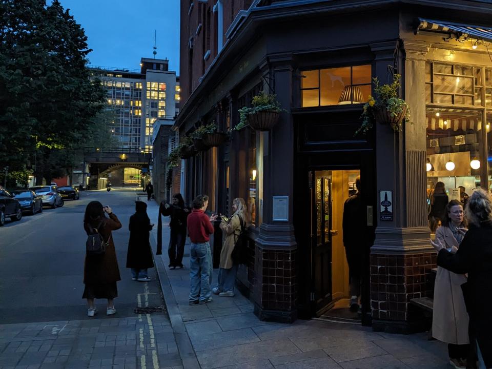 Photo of Swifties chatting with each other and taking pictures outside The Black Dog pub