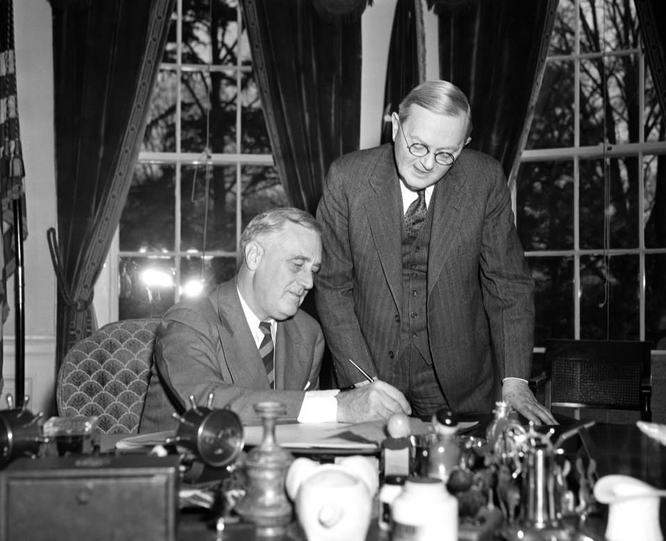 FILE - In this April 2, 1940 file photo, William L. Austin, director of the U.S. Census Bureau, right, helps President Franklin D. Roosevelt fill out the large form at the White House in Washington. Veiled in secrecy for 72 years because of privacy protections, the 1940 U.S. Census is the first historical federal decennial survey to be made available on the Internet initially rather than on microfilm. (AP Photo)